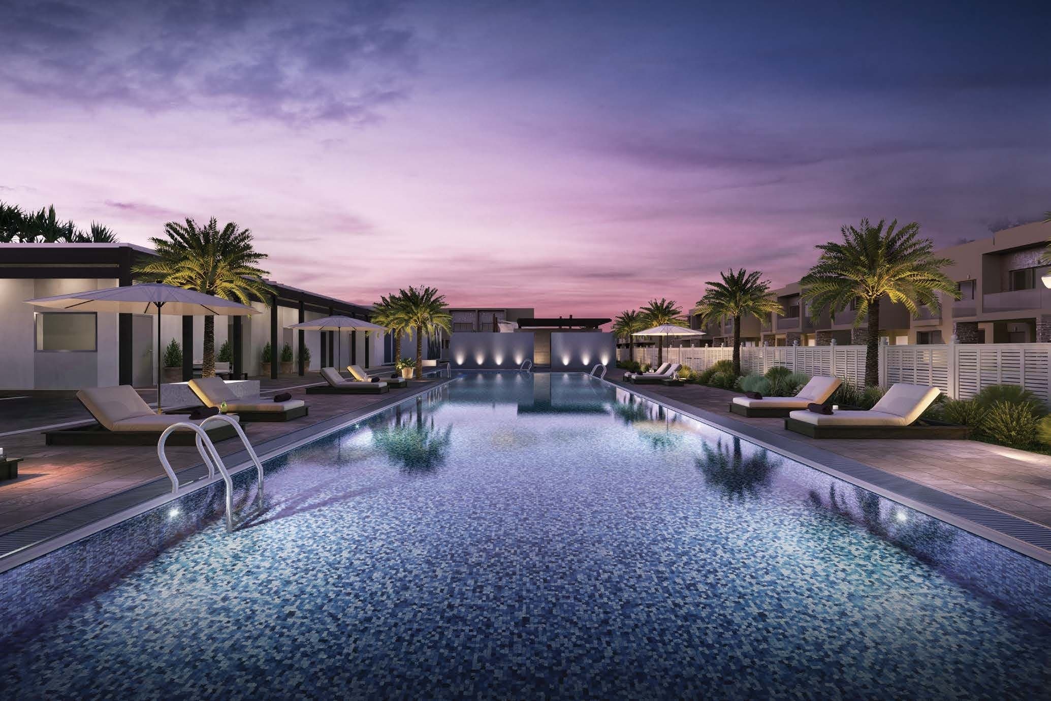 The Orchids at Yas Acres — community swimming pool at dusk